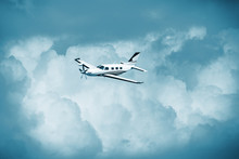 Single Turboprop Aircraft.. Small Private Plane Flying In Blue Clouds.