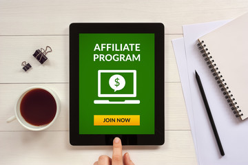 affiliate program concept on tablet screen with office objects on white wooden table. all screen con