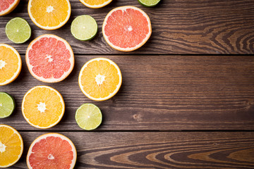 Wall Mural - Colorful citrus halves on wooden table. Food background