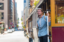 San Francisco Man Riding Cable Car Tramway. Young Casual Guy In His 20s Using Public Transport System In The City To Travel To Work Or University. Summer Tourism.