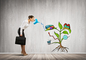 Young businesswoman in empty room watering drawn growth concept with can