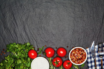 Fresh basil and cherry tomatoes on the dark background with spices. Top view with copy space.