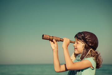 happy kid playing outdoor against sea and sky