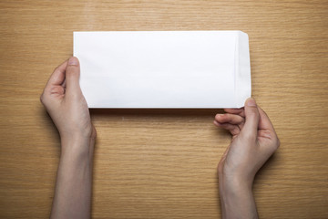 woman hand hold a letter with envelope on the wood table.