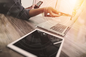 Poster - creative working with mobile phone and digital tablet and laptop computer on wooden desk in modern office with virtual icon diagram