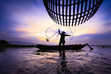 Silhouette Fisherman Throwing Fishing Net During Sunrise