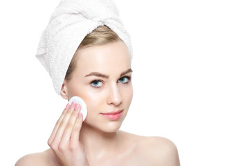 Wall Mural - young blond woman with towel in her hair removing make up. smiling pretty girl with perfect complexi