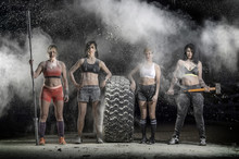 Portrait Of Women Standing With A Hammer And Barbell Posing With A Tire In The Dust