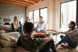 © Drobot Dean - Group of people eating pizza and relaxing in living room
