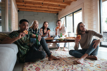 Wall Mural - Five friends sitting in house and eating pizza