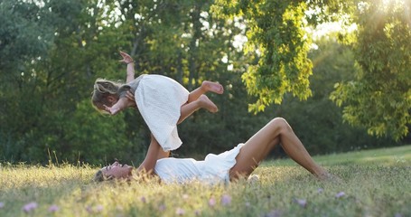 ecology, young mother with her adorable two year old girl playing outdoors with love. concept of family love of nature. happy children with the love of parents. concept of green and sustainability.