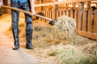 © rh2010 - Close-up view on the legs of farmer working with hay at the animal barn