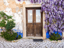 Purple Wisteria Plant Growing Arounf Doors Of An Old House In Portugal