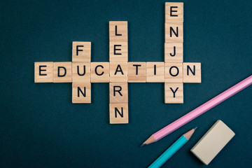 Wood block educaiton word over backboard school. Education word with pencil and eraser on black background. Topview