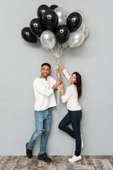 Poster - Smiling loving couple holding balloons.