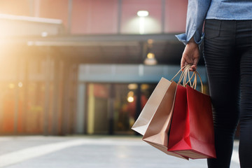 woman with shopping bags in shopping mall background.