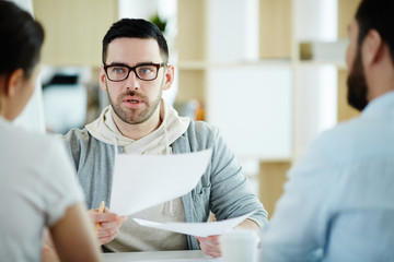 Canvas Print - Portrait of  adult man dressed in business casual discussing work with colleagues at meeting table in modern office