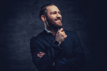 Bearded male dressed in a blue jacket over grey vignette background.