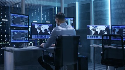 Poster - Technical Controller Working at His Workstation with Multiple Displays. He's Alone in System Control Center. Shot on RED EPIC-W 8K Helium Cinema Camera.