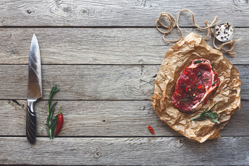 Sticker - Raw beef steak on dark wooden table background, top view