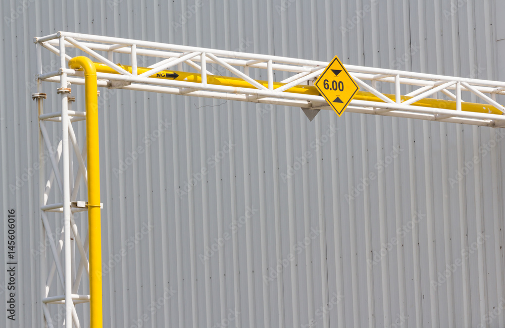 Height Restriction limit Sign on pipe rack, yellow metal sign on steel structure