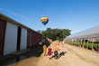 © Sarah Rypma - Family walking on path with hot air balloon in sky