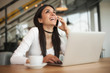 © guruXOX - Happy woman having cell telephone conversation while sitting in cafe