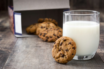 Chocolate chip cookies and milk on wooden table background
