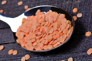 Wall Mural - Spoon with red lentils on table