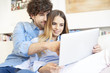 © gzorgz - Spend time together. Shot of a smiling young woman and an affectionate handsome man relaxing at home and using laptop.