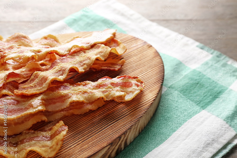 Fried bacon slices on wooden board