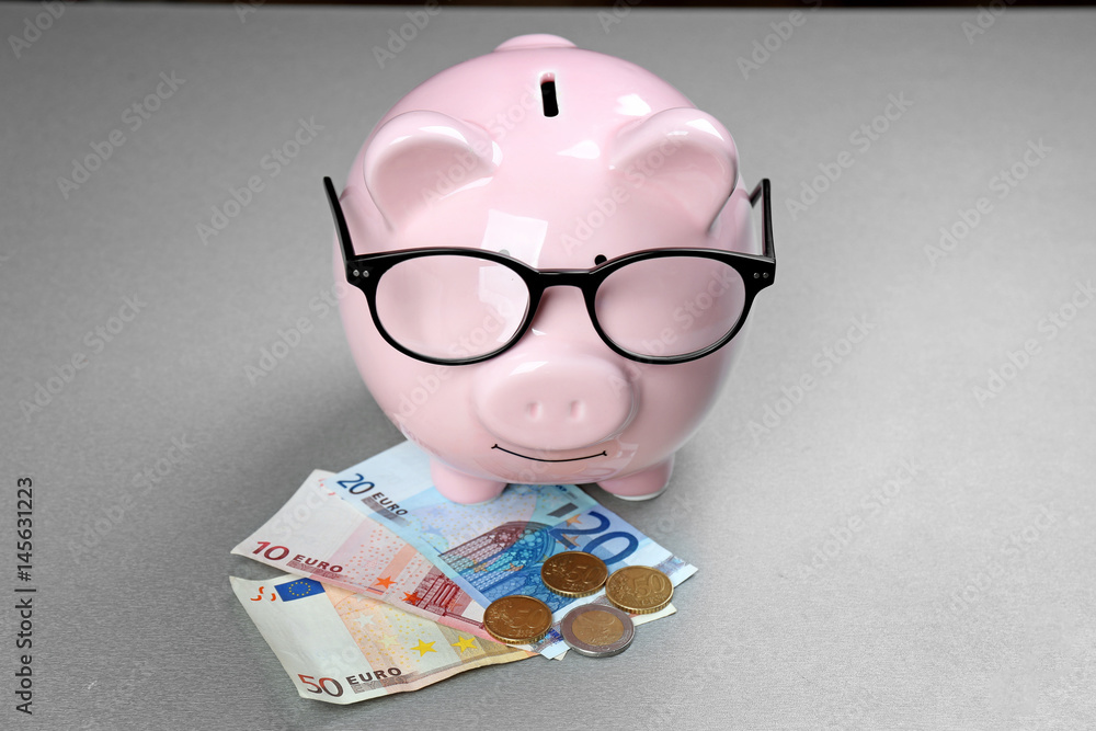 Saving electric power concept. Ceramic piggy bank with money on grey background