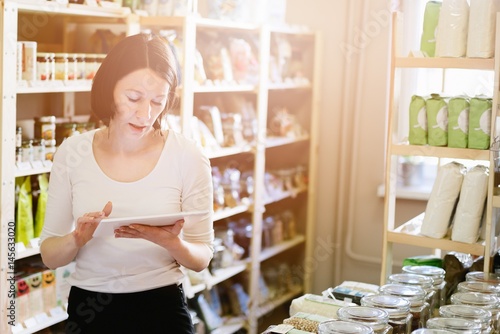 Fotografía Woman owner of store with healthy food ordering products with a tablet