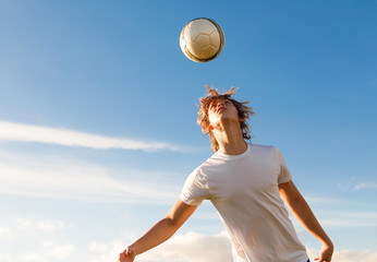 male soccer / football player hitting the ball with his head.