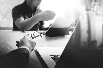 two colleague web designer discussing data and digital tablet docking keyboard and computer laptop with smart phone and design diagram on marble desk,black white