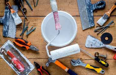 building decoration instruments with paint, roller, palette-knife on wooden background top view