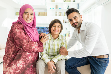 Wall Mural - Happy Arabic Muslim family at modern home having fun and good time together