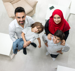 Wall Mural - Happy Arabic Muslim family at modern home having fun and good time together