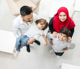 Wall Mural - Happy Arabic Muslim family at modern home having fun and good time together