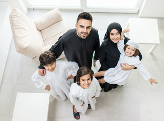 High angle view portrait of happy Arabic Muslim family at new modern home