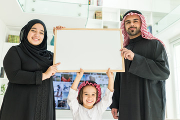 Wall Mural - Happy Arabic Muslim family at modern home having fun and good time together