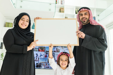 Wall Mural - Happy Arabic Muslim family at modern home having fun and good time together