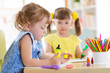 © Oksana Kuzmina - Two beautiful cute kids little girls are drawing at home or daycare centre.