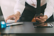 © everythingpossible - close up of businessman working with smart phone and laptop and digital tablet computer in modern office