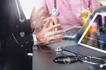 Medical co working concept,Doctor working with smart phone and digital tablet and laptop computer to meeting his team in modern office at hospital with virtual icon diagram