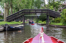 Tourists In Small Boats Under The Bridges Of Giethoorn