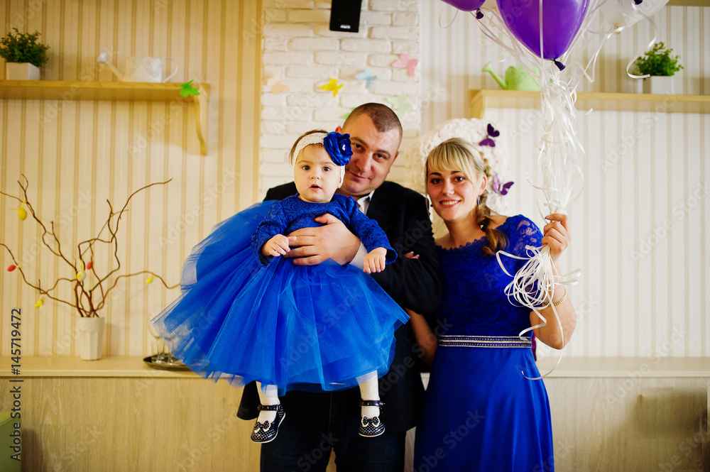 Cute little baby girl at blue dress on hands of father and mother. 1 year  birthday day. Stock Photo | Adobe Stock