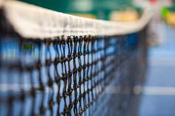 close up view of tennis court through the net
