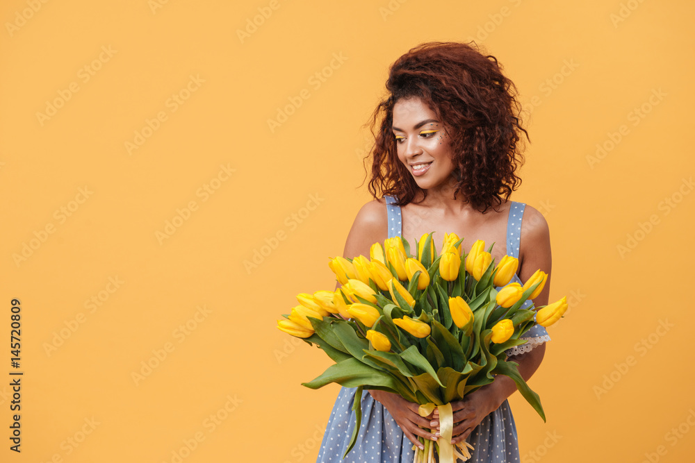 Smiling African woman holding bouquet of flowers Stock Photo | Adobe Stock