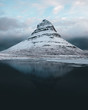 © Michael Schauer - Reflection of Kirkjufell snowcapped mountain in lake against cloudy sky